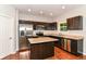 Updated kitchen featuring stainless steel appliances, dark wood cabinets, and an island at 5171 Alpine Violet Way, Indianapolis, IN 46254