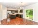 Open kitchen with stainless steel appliances, dark wood cabinets, and access to a backyard patio at 5171 Alpine Violet Way, Indianapolis, IN 46254