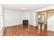 Bright living room with fireplace, wood floors, and view of the staircase and entry at 5171 Alpine Violet Way, Indianapolis, IN 46254