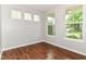 Bright room featuring gleaming hardwood floors and an abundance of natural light streaming through the windows at 5171 Alpine Violet Way, Indianapolis, IN 46254
