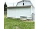 Exterior view showing the home's white siding and functional storage options, along with well-maintained green lawn at 8418 S State Road 39, Clayton, IN 46118
