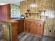 View of kitchen bar with wood paneled wall, shelving, and a glimpse into another room at 8418 S State Road 39, Clayton, IN 46118