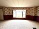 Bright living room with carpeted floors, large window, and floral wallpaper, creating a cozy and inviting atmosphere at 8418 S State Road 39, Clayton, IN 46118