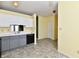 Open-concept kitchen with grey lower cabinets and a sleek black dishwasher at 11218 Boston Way, Fishers, IN 46038