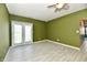 Bright living room featuring tiled floors, a double door exit, and a ceiling fan at 11218 Boston Way, Fishers, IN 46038