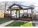 Charming home featuring an inviting covered porch with stylish seating and a vibrant green door at 1529 Harlan St, Indianapolis, IN 46203