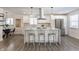 Open concept kitchen with island seating, white cabinets, and hardwood floors at 1529 Harlan St, Indianapolis, IN 46203