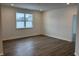 Spacious bedroom with wood-look flooring and large window at 5226 Woodhurst Ln, Indianapolis, IN 46239