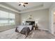 Relaxing bedroom featuring a tray ceiling, neutral decor, and a large window for natural light at 17345 Northam Dr, Westfield, IN 46074