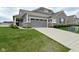 Beautiful home showcasing a concrete driveway, gray siding, brick accents, lush lawn and attached two car garage at 17345 Northam Dr, Westfield, IN 46074