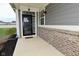 Inviting front entrance with a stylish black door, brick accents, and a small porch, plus installed security system at 17345 Northam Dr, Westfield, IN 46074