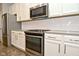 Well-equipped kitchen with stainless steel appliances, white cabinetry, tile backsplash, and modern finishes at 17345 Northam Dr, Westfield, IN 46074