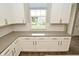Bright kitchen features white cabinets, gray countertops, subway tile backsplash, and window view at 17345 Northam Dr, Westfield, IN 46074