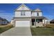 Two-story home featuring gray siding, brick facade, two-car garage, and a well-manicured front lawn at 6196 Granby Dr, Whitestown, IN 46075