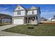 Stylish two-story home featuring gray siding, brick accents, attached garage, and newly planted front yard at 6196 Granby Dr, Whitestown, IN 46075