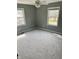An empty bedroom with two windows provides natural light and features neutral paint and new carpeting at 927 Stockton St, Indianapolis, IN 46260