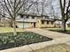 Traditional two story home with an attached two car garage and a well landscaped yard with mulch and flowering bulbs at 927 Stockton St, Indianapolis, IN 46260