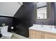Stylish powder room with dark walls, modern mirror, light wood vanity, and contemporary fixtures at 560 Jefferson Ave, Indianapolis, IN 46201