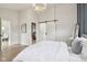 A light and bright bedroom featuring wood flooring and a modern chandelier at 560 Jefferson Ave, Indianapolis, IN 46201