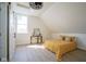 Bright bedroom with a mustard-yellow comforter, and a barn door leading to the bathroom at 560 Jefferson Ave, Indianapolis, IN 46201