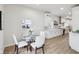 Cozy dining area with a glass table, white chairs, and a view into the modern, well-equipped kitchen at 560 Jefferson Ave, Indianapolis, IN 46201