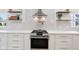 Close-up of the range wall, showcasing the stainless steel range and hood, tiled backsplash and open shelving at 560 Jefferson Ave, Indianapolis, IN 46201
