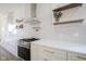Modern kitchen features a stainless steel range and floating shelves at 560 Jefferson Ave, Indianapolis, IN 46201