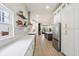 Contemporary kitchen featuring stainless steel appliances, white cabinets, and open layout leading to the living area at 560 Jefferson Ave, Indianapolis, IN 46201