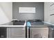 New front load Samsung washer and dryer in gray-walled laundry room at 560 Jefferson Ave, Indianapolis, IN 46201