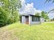 View of the home's screened porch and exterior, surrounded by green lawn and trees at 7650 Clarion Dr, Indianapolis, IN 46236
