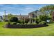 Lush backyard with a stone retaining wall, mature trees, and a balcony with large windows at 9454 Raintree S Dr, Columbus, IN 47201