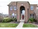 Stately brick home with arched entryway, manicured shrubs and walkway at 11704 Gray Eagle Dr, Fishers, IN 46037