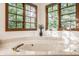 Bright bathroom featuring a marble tub with bronze fixtures, framed by beautiful wooden window casings at 1462 Eagle Trace Ct, Greenwood, IN 46143