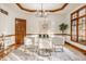 Dining room with a glass table, stylish chairs, and modern chandelier lighting at 1462 Eagle Trace Ct, Greenwood, IN 46143