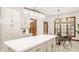 Spacious kitchen featuring white cabinets, a white island and an adjacent dining area with a large window at 1462 Eagle Trace Ct, Greenwood, IN 46143