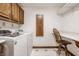 Functional laundry room with appliances, wooden cabinets, and built-in folding table at 1462 Eagle Trace Ct, Greenwood, IN 46143