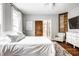 Bright bedroom with a queen bed, exposed brick accent, modern decor, and ceiling fan at 545 Fletcher Ave, Indianapolis, IN 46203
