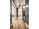Hallway with light wood floors leads to a bright kitchen and living room, featuring modern lighting and a convenient built-in bar at 545 Fletcher Ave, Indianapolis, IN 46203