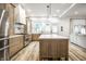 Open kitchen with stainless steel appliances, large island, custom cabinetry, and access to living area at 545 Fletcher Ave, Indianapolis, IN 46203