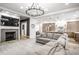 Inviting living room with a fireplace, gray sectional sofa, stylish lighting, and open kitchen access at 545 Fletcher Ave, Indianapolis, IN 46203