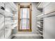 Bright walk-in closet featuring custom shelving, drawers and a window for natural light at 545 Fletcher Ave, Indianapolis, IN 46203
