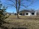 Home's exterior view with large backyard, featuring a mix of mature trees at 5143 Oak Ridge Pl, Columbus, IN 47201