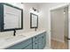 Bright bathroom featuring double vanity with blue cabinets and framed mirrors at 5143 Oak Ridge Pl, Columbus, IN 47201