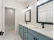 Bright bathroom featuring double vanity with blue cabinets and a tiled shower at 5143 Oak Ridge Pl, Columbus, IN 47201