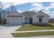 Charming one-story home featuring white board and batten siding, a gray roof, and an attached two-car garage at 5143 Oak Ridge Pl, Columbus, IN 47201