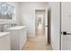 Bright laundry room featuring modern washer and dryer with view of hallway and natural light at 5143 Oak Ridge Pl, Columbus, IN 47201