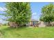 Spacious green backyard with a patio, stone fireplace, and mature trees perfect for entertaining at 10346 Strongbow Rd, Fishers, IN 46040