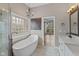 A modern bathroom with a freestanding tub, stylish vanity, and a window allowing in natural light at 10346 Strongbow Rd, Fishers, IN 46040