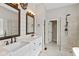 Bathroom featuring double sinks, decorative mirrors, and a glass shower at 10346 Strongbow Rd, Fishers, IN 46040