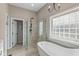 Bathroom with a soaking tub, tile shower, and a large window at 10346 Strongbow Rd, Fishers, IN 46040